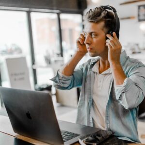 man working at laptop with headphones