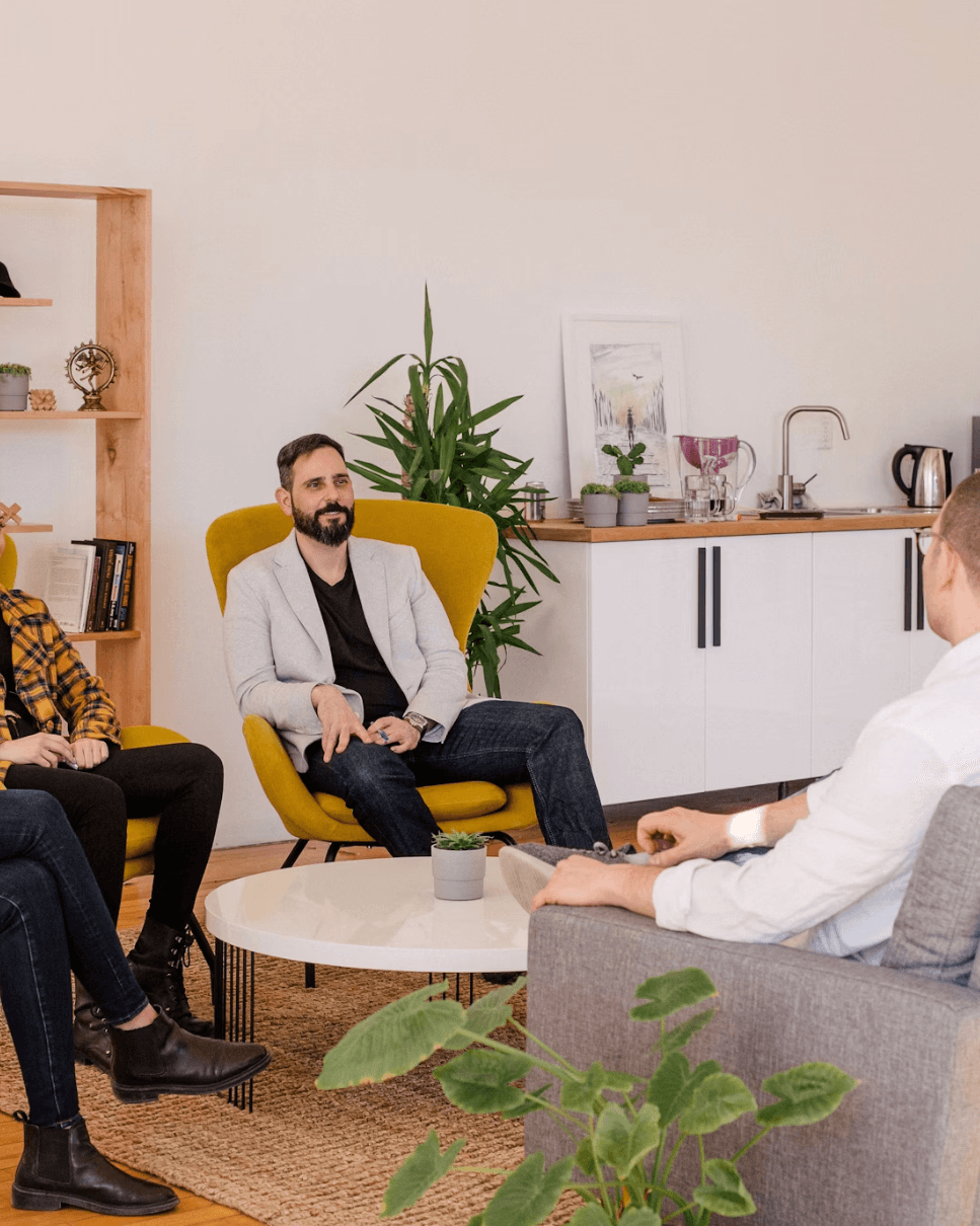 man sitting in yellow chair with colleague