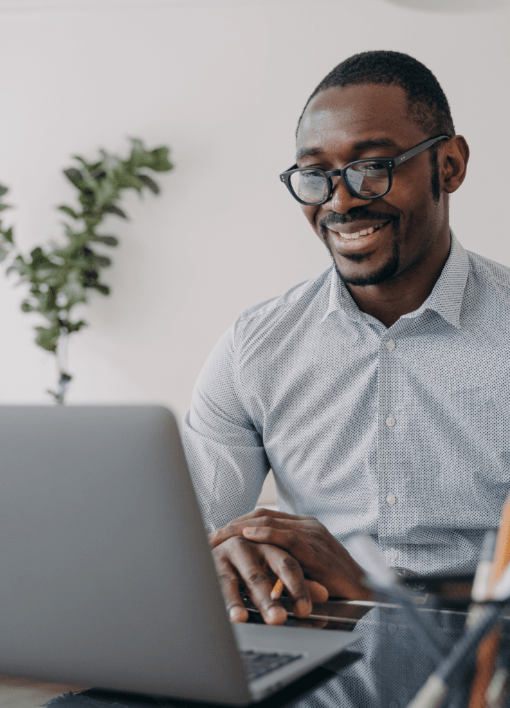 Man in glasses looking at laptop screen and smiling to illustrate comfort in IR35 knowledge relating to small busineses