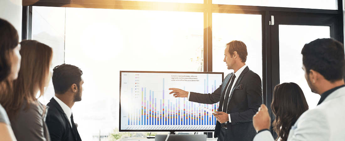 office meeting room with man in suit showing a presentation screen to illustrate checking the business size of clients for IR35 purposes